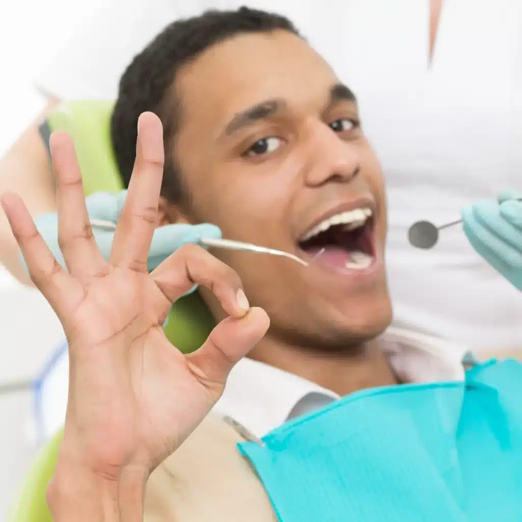 Patient giving an OK sign during a tooth filling appointment